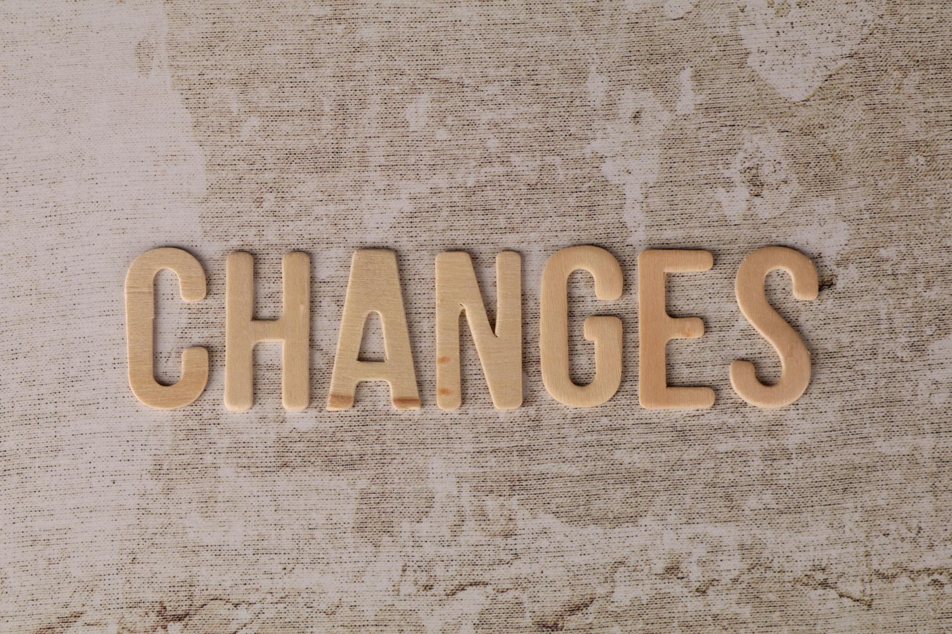 wooden letters spell out changes on textured background